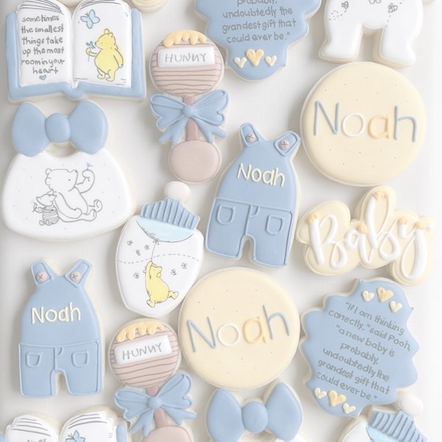 Image of sugar cookies design like farmer's overalls and baby rattles in pastel colors